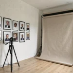 Studio de photographie portrait en Loire-Atlantique avec des tirages encadrés sur un mur blanc et un trépied professionnel